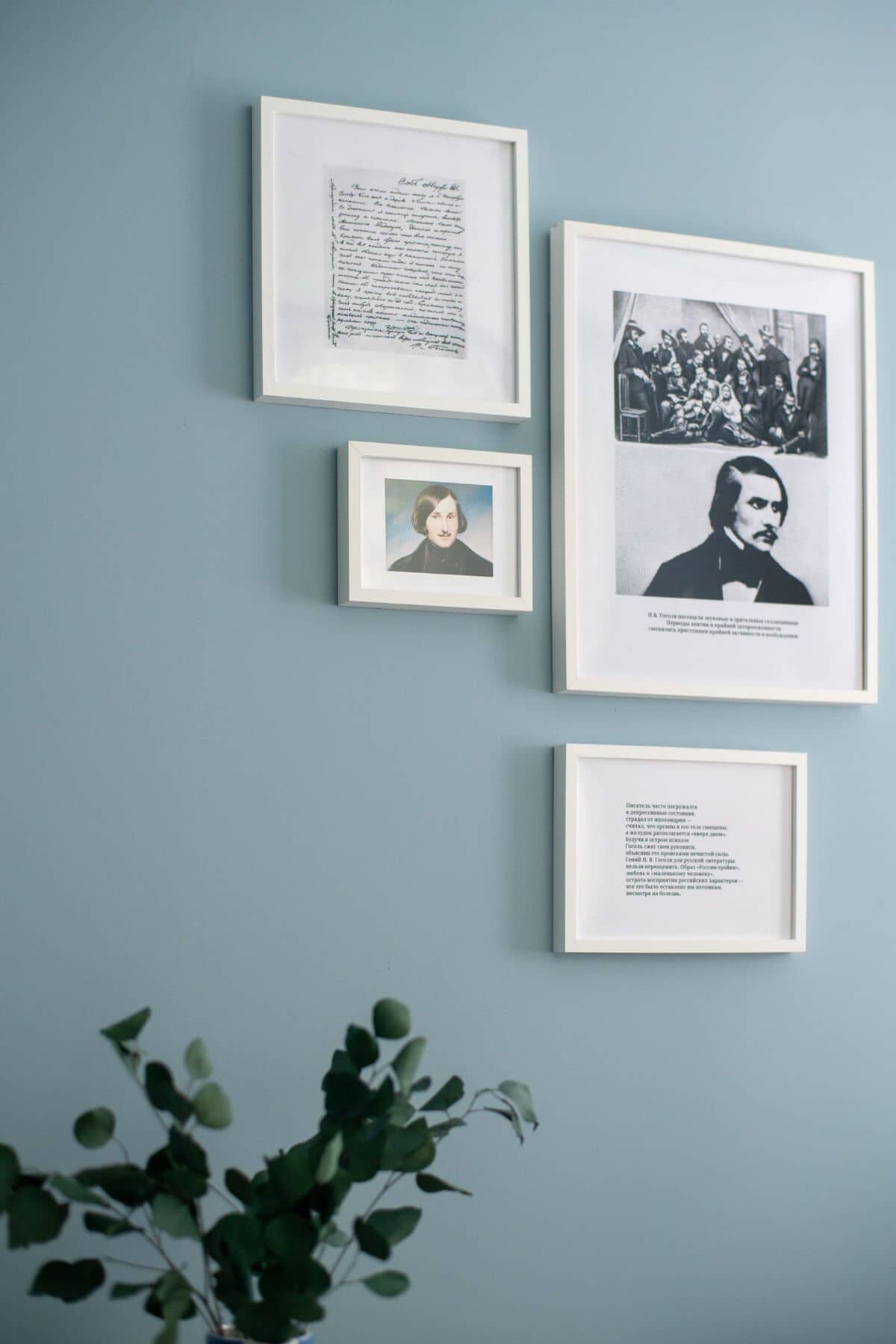 Галерея с четырьмя изображениями в рамках на синей стене