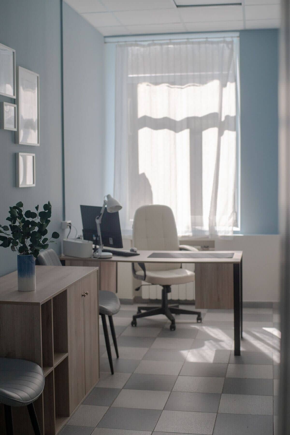 Светлый минималистичный офис с окном, закрытым прозрачными шторами