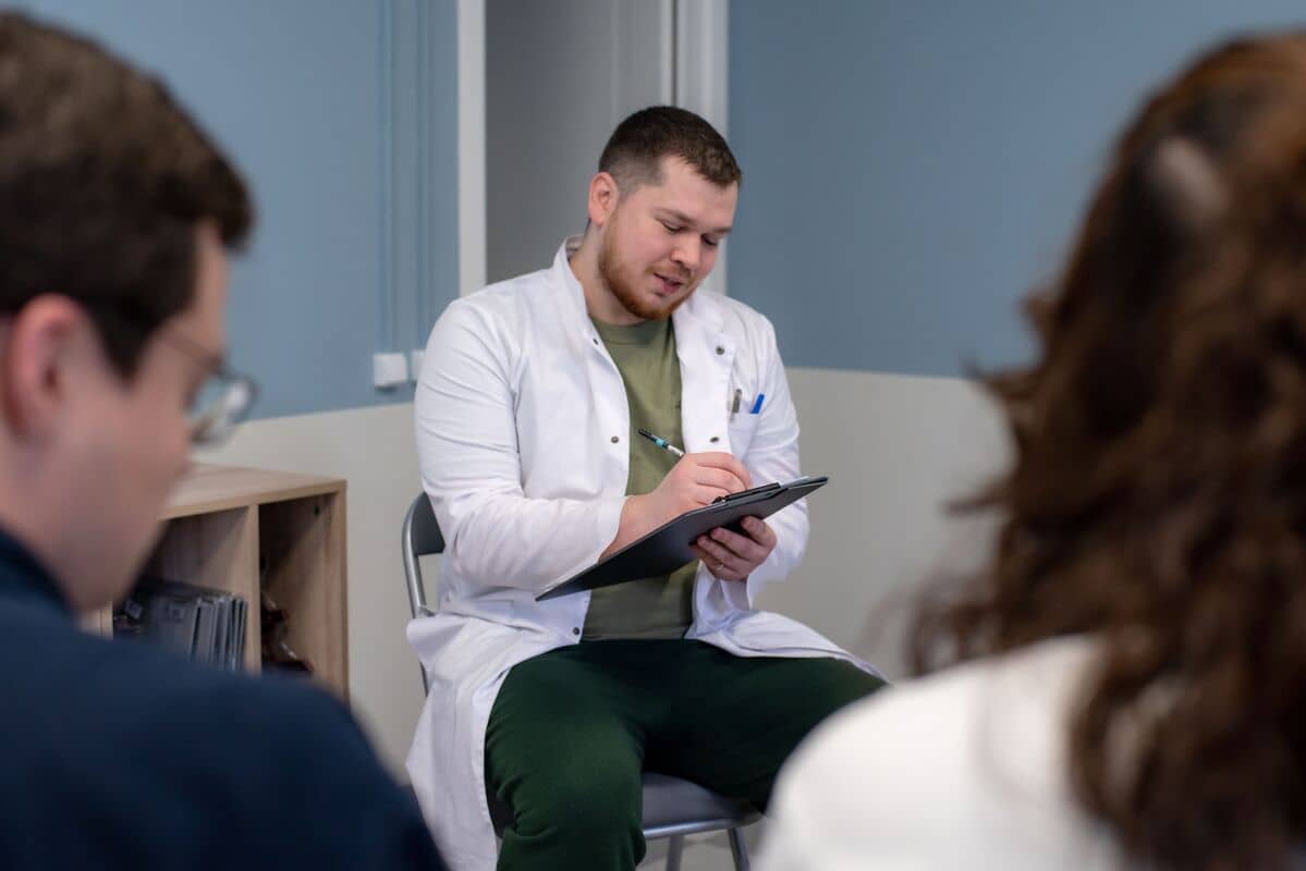 Медицинский работник делает заметки во время группового обсуждения.