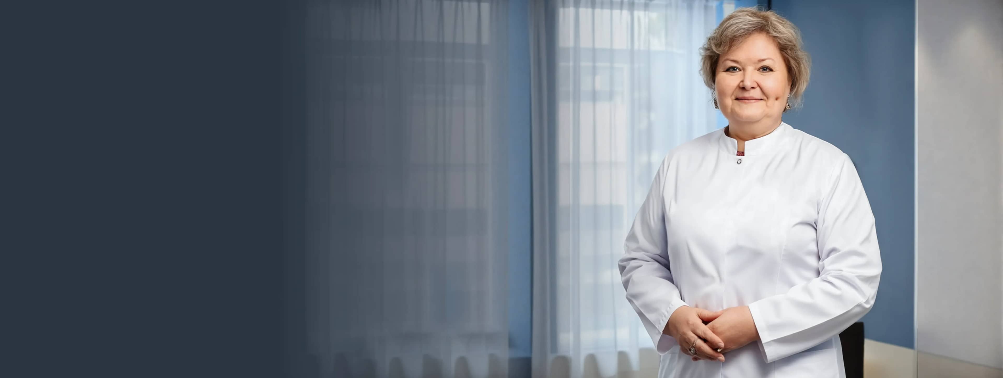 Уверенная в себе женщина в белом халате стоит в мягко освещенной комнате