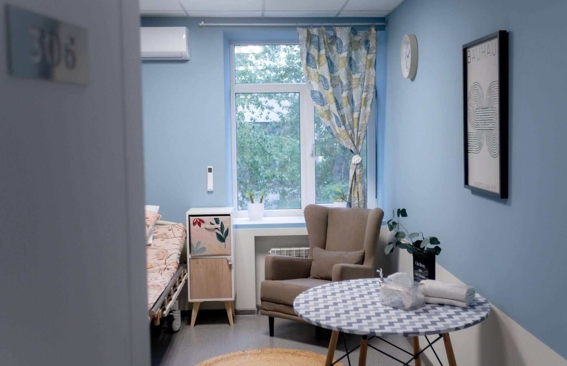 Уютная комната с синими стенами, окном с узорчатыми шторами и креслом